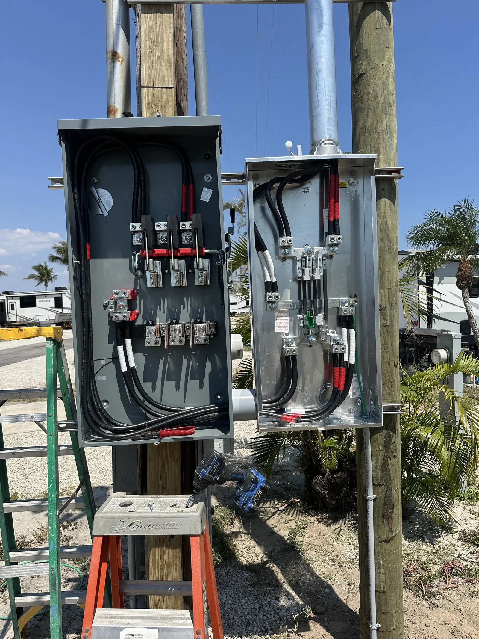 Open 600 amp disconnect and meter enclosures mounted on a pole at an RV park