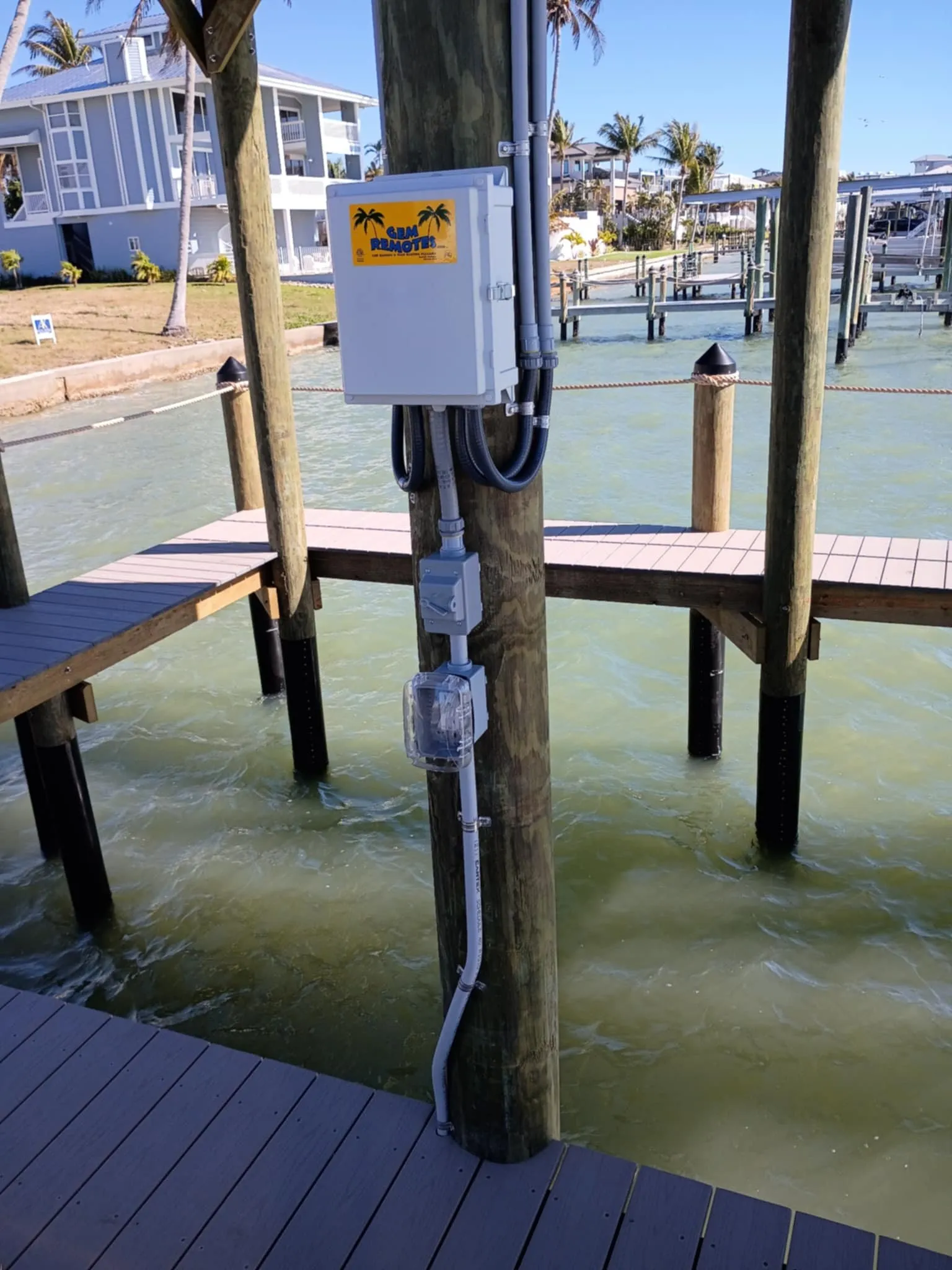 Boat lift control box and conduit mounted on a dock piling over the water